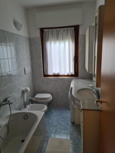 a bathroom with a tub and two sinks and a toilet at casa di Ale e Bea in Dervio