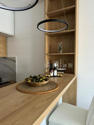 a dining room table with a bowl of food and a chandelier at Spa Koncept-Apartmani in Veliko Gradište