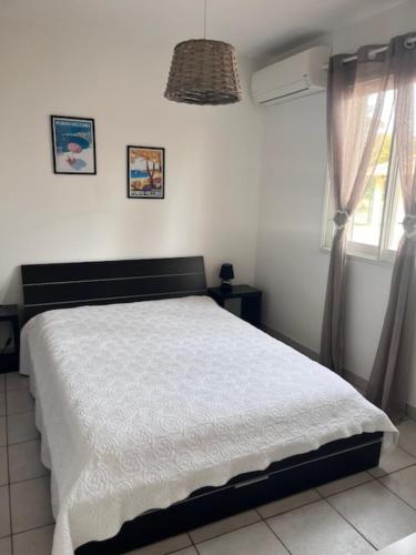 - une chambre avec un lit blanc et 2 fenêtres dans l'établissement Appt T2 Standing avec Piscine et Terrasse, à Porto-Vecchio