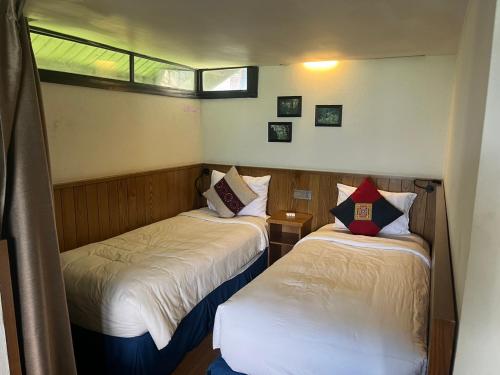 duas camas num pequeno quarto com duas janelas em Heaven house sapa em Lao Cai