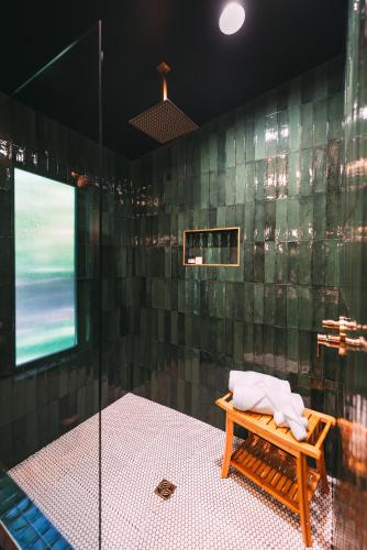 a bathroom with a shower with a bench in it at Romantic Gazebo Cottage w Hot Tub & Pond in Marshallville