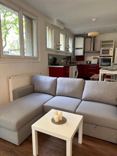un salon avec un canapé et une table dans l'établissement Appartement avec jardin à 5min de Paris, à Alfortville