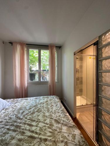 une chambre avec un lit et une douche en verre dans l'établissement Appartement avec jardin à 5min de Paris, à Alfortville