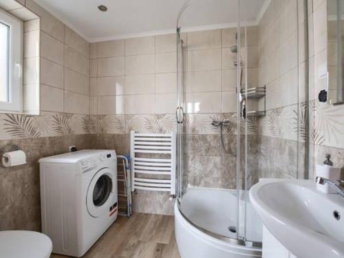 a bathroom with a washing machine and a bath tub at Nowy domek w Pieninach in Grywałd