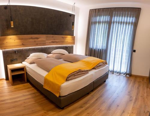 a bedroom with a large bed with a large wooden headboard at Hotel Christin in Ora/Auer