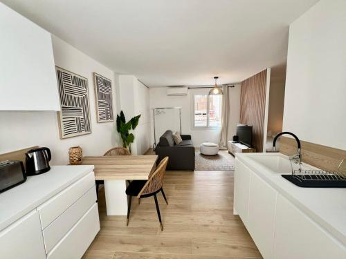 une cuisine et un salon avec une table et un canapé dans l'établissement C003 Cosy a 200 m du Palais plein centre Cannes, à Cannes
