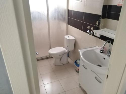 La salle de bains est pourvue de toilettes blanches et d'un lavabo. dans l'établissement Egepar Rezidance Apart, à Buca