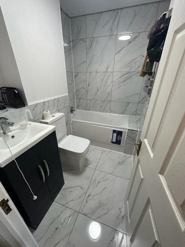 a bathroom with a white toilet and a sink at Ian house abbeywood in Abbey Wood