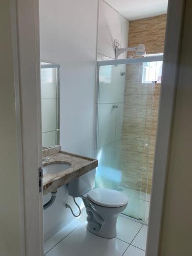 a bathroom with a toilet and a sink and a shower at Apto Aconchegante - 600m da Pç Mestre Dominguinhos in Garanhuns