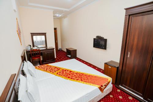a hotel room with a bed and a mirror at Yangi Sharq in Samarkand