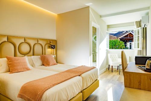 Schlafzimmer mit einem Bett, einem Schreibtisch und einem Fenster in der Unterkunft CORTIJO LANDETE in Granada