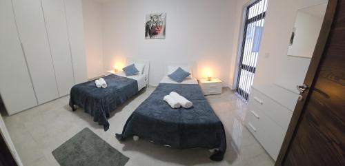 Cette petite chambre comprend deux lits et un canapé. dans l'établissement Green Valley, à Żebbuġ