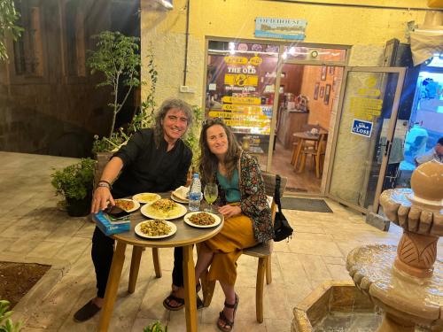 un hombre y una mujer sentados en una mesa con comida en the old house en Kerak