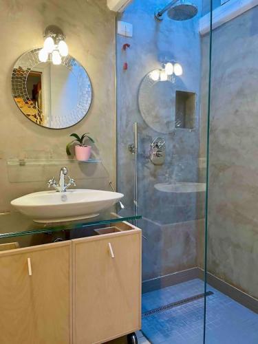 a bathroom with a sink and a glass shower at Romeos Cottage Public free parking 2 bedrooms in Verona