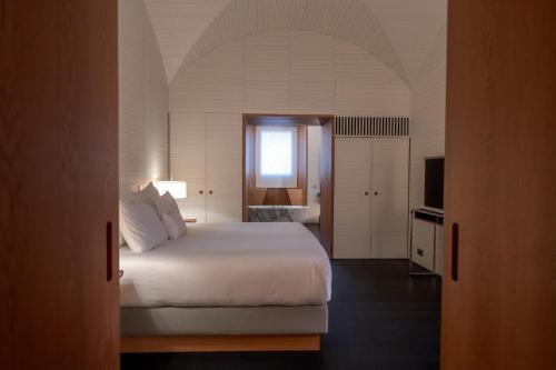 a bedroom with a white bed and a window at Atrio in Cáceres