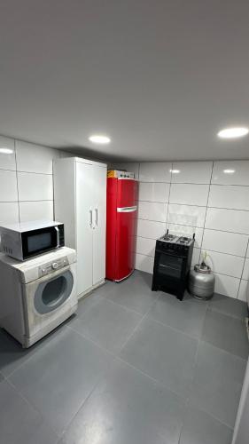 una cucina con lavatrice e frigorifero rosso di Alves residencial a Joinville
