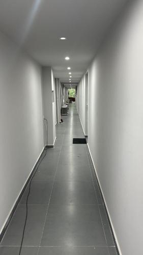 un lungo corridoio con pareti bianche e pavimento piastrellato di Alves residencial a Joinville