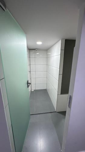 bagno con cabina doccia e piastrelle bianche di Alves residencial a Joinville