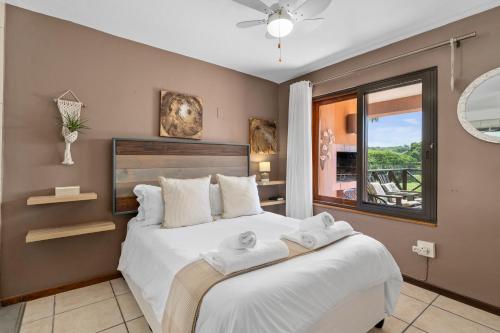 a bedroom with a large white bed with a window at San Lameer Villa 10412 - 1 Bedroom Classic - 2 pax - San Lameer Rental Agency in Southbroom