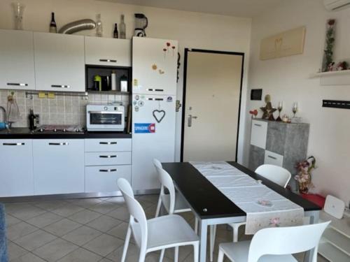 eine Küche mit einem Tisch und Stühlen sowie einem Kühlschrank in der Unterkunft Appartamento vista mare in Albenga