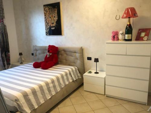 ein roter Teddybär auf einem Bett im Schlafzimmer in der Unterkunft Appartamento vista mare in Albenga