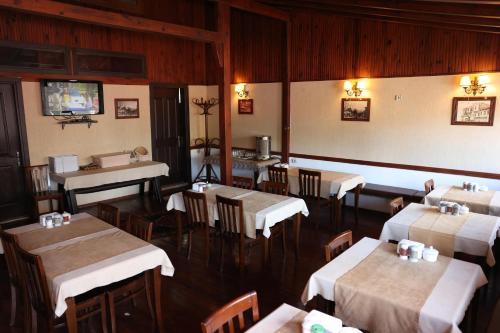 a dining room with tables and chairs and a tv at Dünya Otel Adana in Seyhan