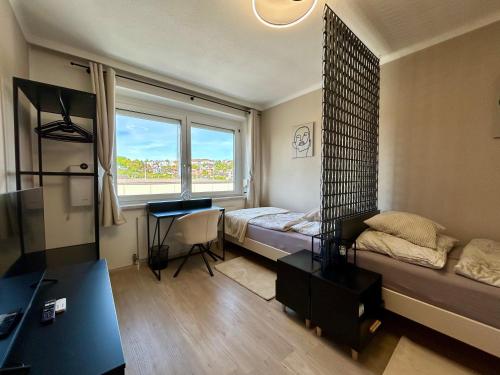 1 dormitorio con cama, escritorio y ventana en StayRoom Apartments I "U151", en Linz