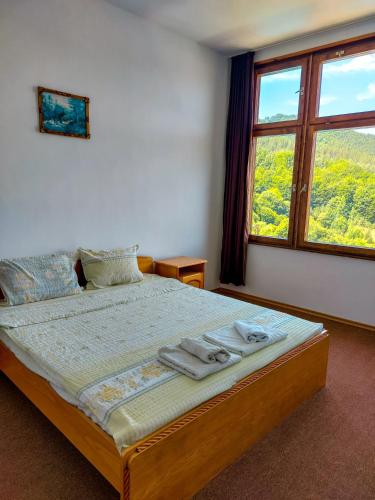 ein Schlafzimmer mit einem Bett mit Handtüchern darauf in der Unterkunft Хотел Кючуковата Къща in Banite