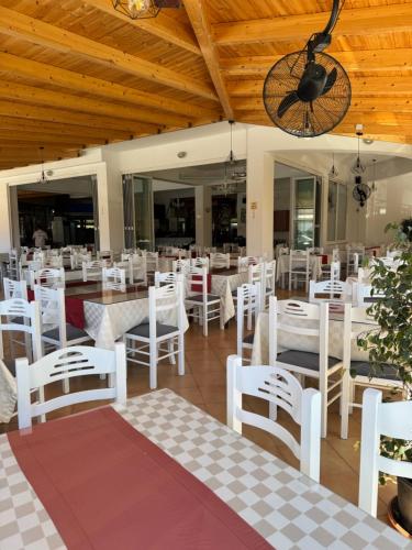 a dining room with white tables and white chairs at Vila Spiro in Ksamil