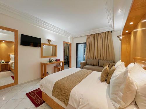 ein Hotelzimmer mit einem Bett und einem TV in der Unterkunft Majliss Hotel Downtown in Rabat