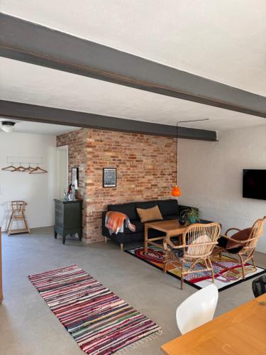 Ellens Have, lejlighed Beate في إيبلتوفت: غرفة معيشة مع أريكة وجدار من الطوب