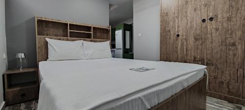 Schlafzimmer mit einem großen Bett mit einem Kopfteil aus Holz in der Unterkunft YOUR HOUSE Apart Otel in Karaköprü Köyü