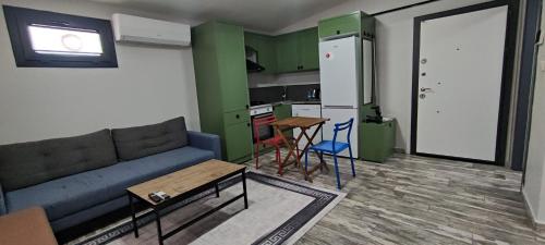 a living room with a couch and a table and a kitchen at YOUR HOUSE Apart Otel in Karaköprü Köyü