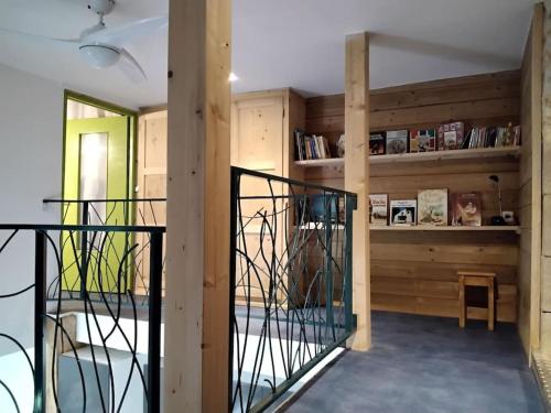 een kamer met houten wanden en een kamer met een balkon bij Gîte LE LOFT chez Judith et Neiges 
