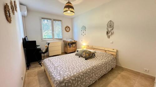 une chambre avec un lit et un bureau dans l'établissement B023 Tres bel appartement proche de la mer a Cannes, à Cannes