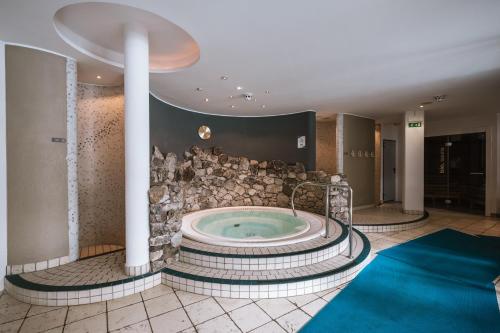 a jacuzzi tub in a lobby with a stone wall at Residenz Feldmühle unterhalb der Burg Taufers in Campo Tures