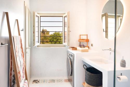 een badkamer met een wastafel en een wasmachine bij Black Tower Villa in Apollonia