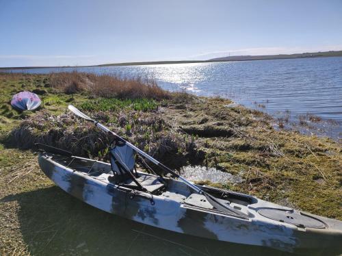 a boat sitting on the shore of a body of water at Castlehill, Sanday in Sanday