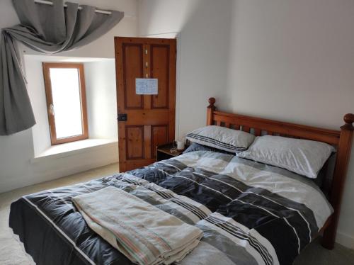 1 cama en un dormitorio con ventana y puerta en Castlehill, Sanday, en Sanday