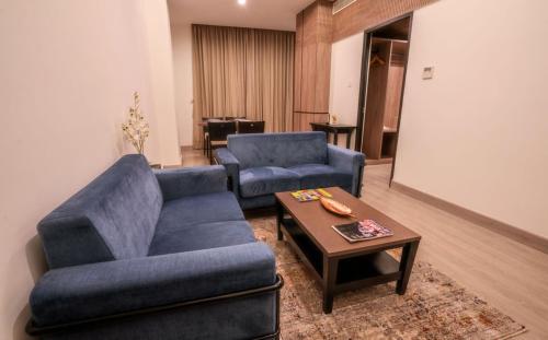 a living room with a blue couch and a coffee table at Hotel Star City in Chennai