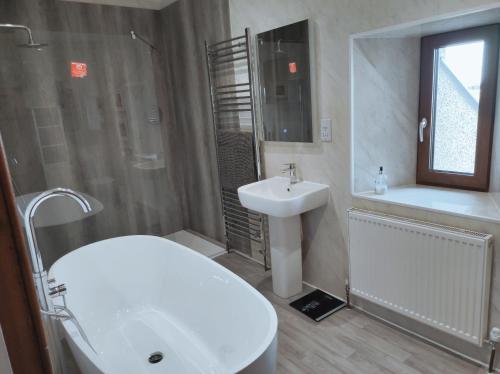 uma casa de banho com um lavatório, um WC e uma banheira e um lavatório. em Castlehill, Sanday em Sanday