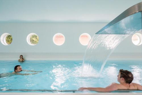 two people in the water in a swimming pool at Hotel & Restaurant Hanse Kogge in Ostseebad Koserow