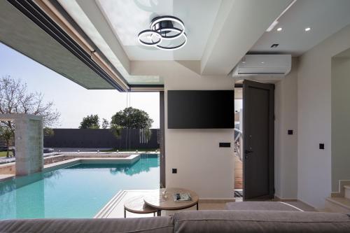 een woonkamer met een zwembad en een bank bij Elinor Villa in Chania