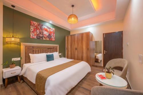 a bedroom with a large bed and a chair at Saanjh - The Musical Sunset in Shimla