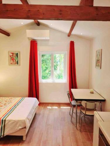 une chambre avec deux lits et une table et une fenêtre dans l'établissement Le logis de Rigoumel 2, à Toulon