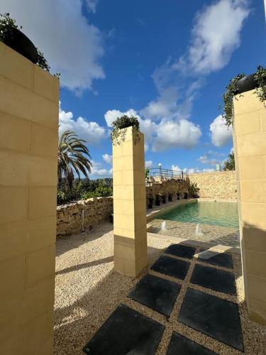 a view of a pool of water with two columns at Villa Vera with private pool near Valletta in Tal-Pietà