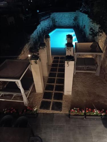 a swimming pool at night with a table and chairs at Villa Vera with private pool near Valletta in Tal-Pietà