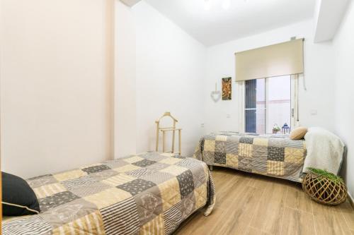 - une chambre avec 2 lits et une fenêtre dans l'établissement Bettatur Apartament Anfiteatre Romà, à Tarragone