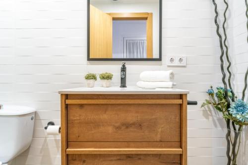 La salle de bains est pourvue d'un lavabo et d'un miroir. dans l'établissement Bettatur Apartament Anfiteatre Romà, à Tarragone