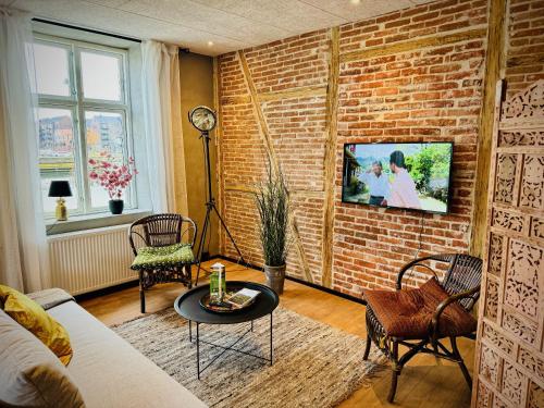 een woonkamer met een bakstenen muur bij Hotel Gammel Havn in Fredericia